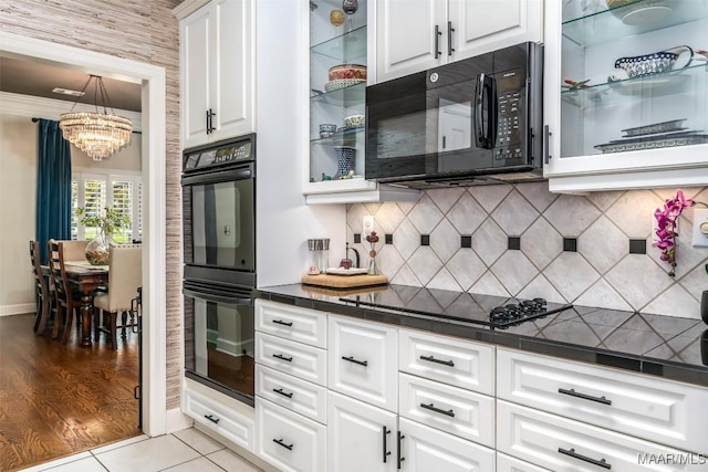 8712 Old Marsh Way, Montgomery, AL 36117 - kitchen featuring black appliances, dark countertops, a chandelier, white cabinets, and glass insert cabinets