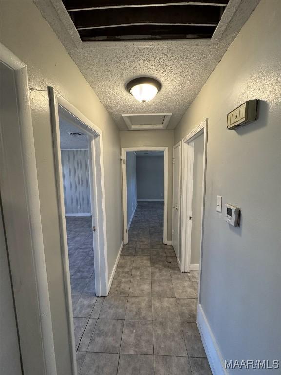 3902 Wesley Dr, Montgomery, AL 36111 - corridor featuring a textured ceiling, tile patterned floors, and attic access