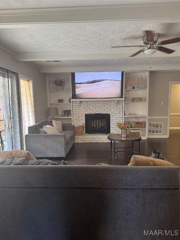 3549 Audubon Rd, Montgomery, AL 36111 - living room featuring wood finished floors, a fireplace, ceiling fan, a textured ceiling, and built in features
