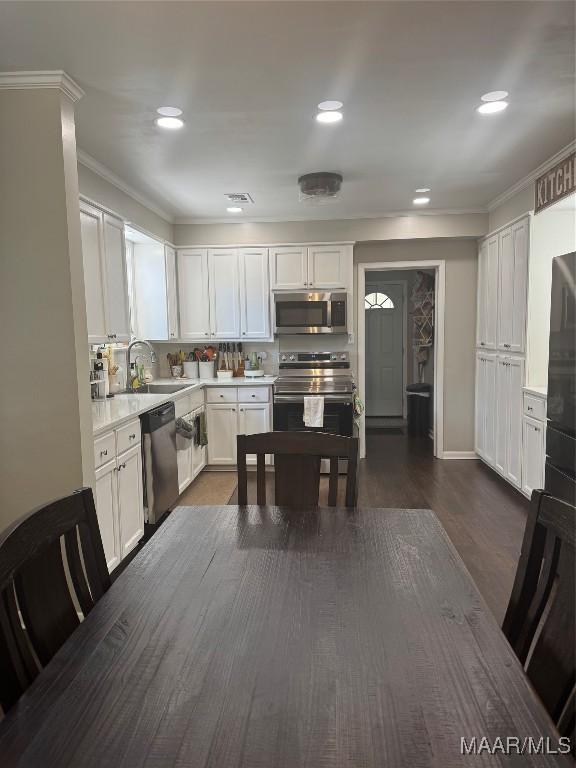 3549 Audubon Rd, Montgomery, AL 36111 - kitchen featuring stainless steel appliances, crown molding, white cabinets, light countertops, and recessed lighting