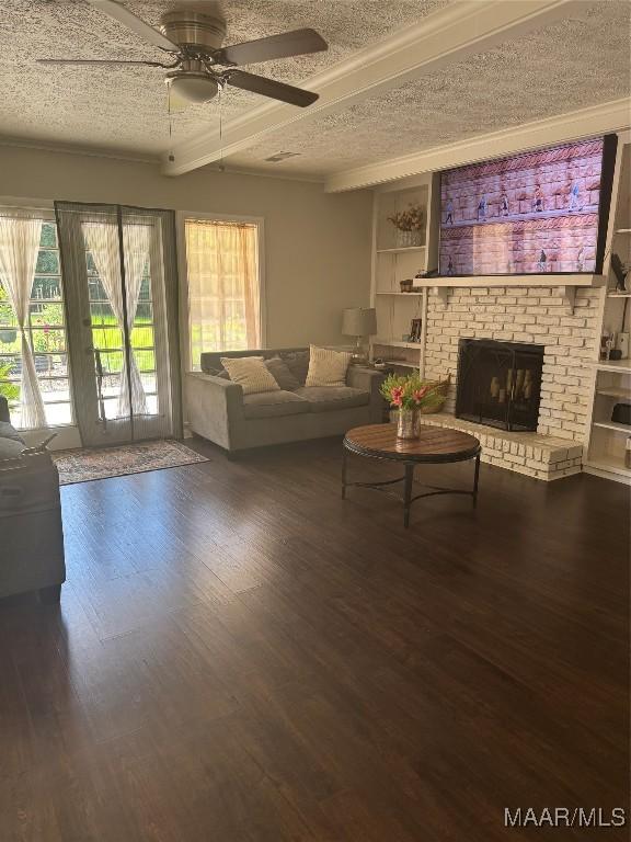 3549 Audubon Rd, Montgomery, AL 36111 - living room with a textured ceiling, a ceiling fan, wood finished floors, a fireplace, and built in features