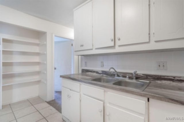 4230 Knollgate Rd, Montgomery, AL 36116 - kitchen featuring white cabinetry, light tile patterned floors, and backsplash
