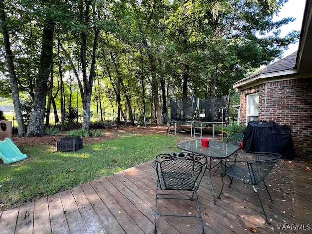 267 River Birch Cir, Wetumpka, AL 36093 - wooden deck with a trampoline, grilling area, outdoor dining area, and a lawn