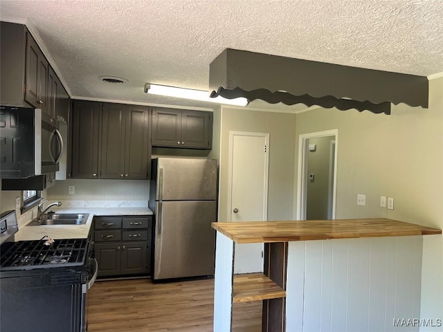 341 Sultan Ct, Montgomery, AL 36117 - kitchen featuring stainless steel appliances, a textured ceiling, butcher block counters, light wood-type flooring, and a peninsula