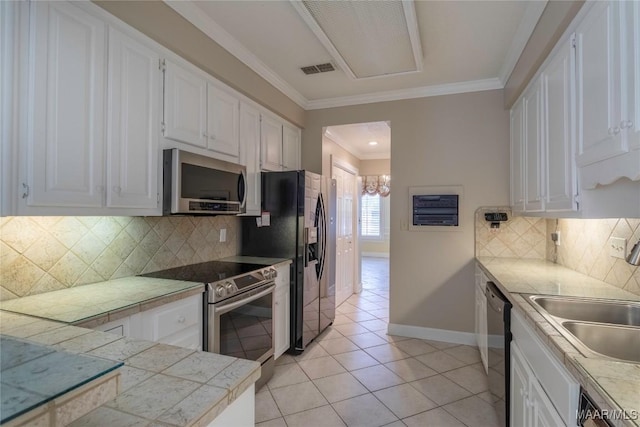 1609 Wentworth Dr, Montgomery, AL 36106 - kitchen with black appliances, white cabinetry, light tile patterned floors, tasteful backsplash, and ornamental molding