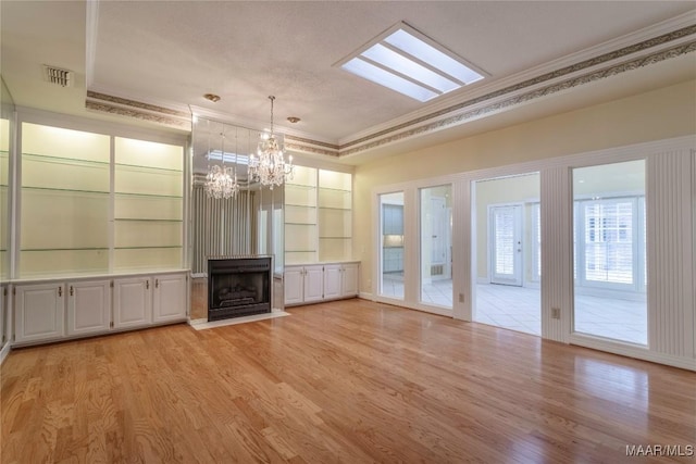 1609 Wentworth Dr, Montgomery, AL 36106 - unfurnished living room featuring crown molding, a chandelier, light wood-type flooring, built in shelves, and a large fireplace