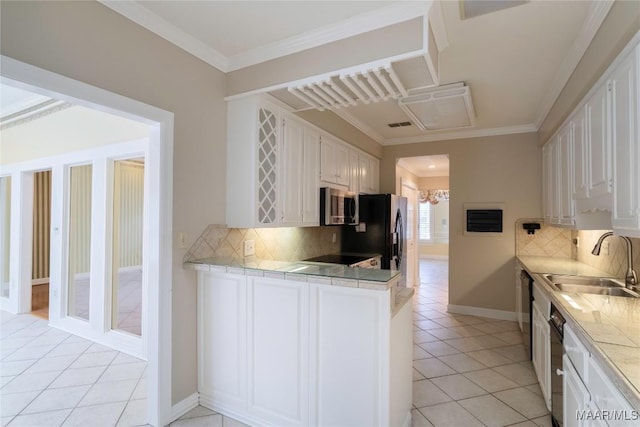1609 Wentworth Dr, Montgomery, AL 36106 - kitchen featuring stainless steel microwave, light tile patterned flooring, white cabinets, black fridge, and ornamental molding