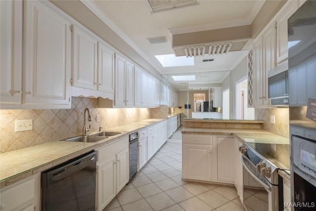 1609 Wentworth Dr, Montgomery, AL 36106 - kitchen with appliances with stainless steel finishes, white cabinetry, tasteful backsplash, light tile patterned floors, and crown molding