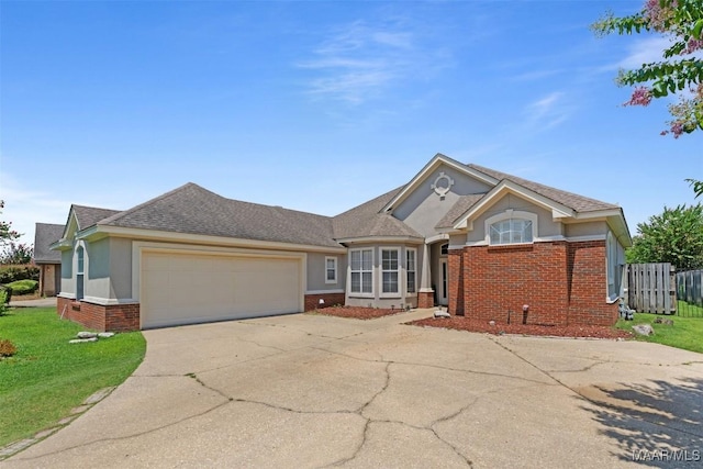 8531 Pipit Ct, Montgomery, AL 36117 - ranch-style house with brick siding, concrete driveway, an attached garage, stucco siding, and a shingled roof