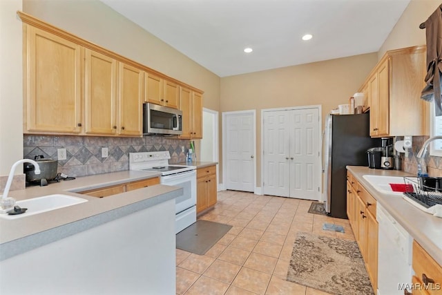 8531 Pipit Ct, Montgomery, AL 36117 - kitchen with appliances with stainless steel finishes, light brown cabinetry, decorative backsplash, light countertops, and light tile patterned flooring