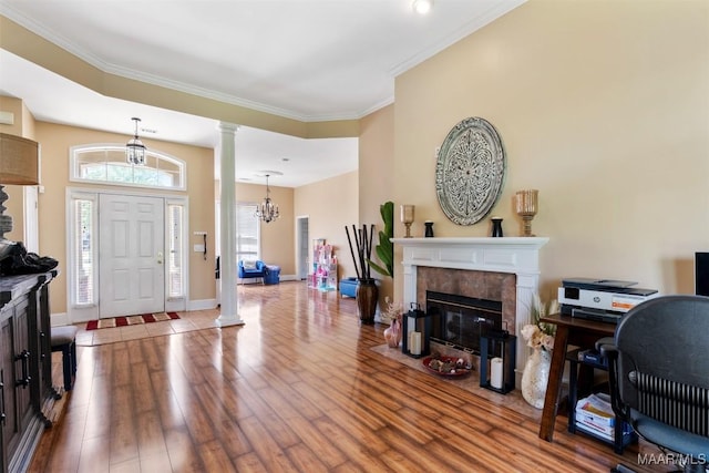 8531 Pipit Ct, Montgomery, AL 36117 - foyer with decorative columns, wood finished floors, a fireplace, ornamental molding, and a chandelier