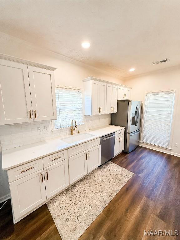 8524 Plantation Ridge Rd, Montgomery, AL 36116 - kitchen featuring appliances with stainless steel finishes, white cabinetry, decorative backsplash, dark wood-type flooring, and recessed lighting