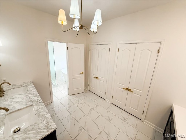 8524 Plantation Ridge Rd, Montgomery, AL 36116 - bathroom with double vanity, marble look tiles, a chandelier, and a freestanding tub