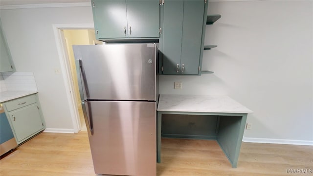 3427 Vance Ln, Montgomery, AL 36109 - kitchen with freestanding refrigerator, open shelves, light wood-type flooring, light countertops, and crown molding