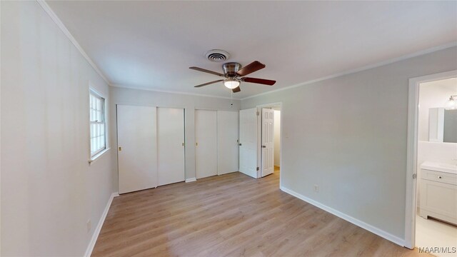 3427 Vance Ln, Montgomery, AL 36109 - unfurnished bedroom featuring ornamental molding, two closets, light wood-style floors, and ensuite bathroom