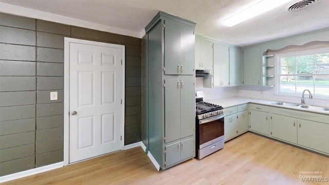 3427 Vance Ln, Montgomery, AL 36109 - kitchen featuring stainless steel gas range oven, light wood-style floors, open shelves, light countertops, and ornamental molding
