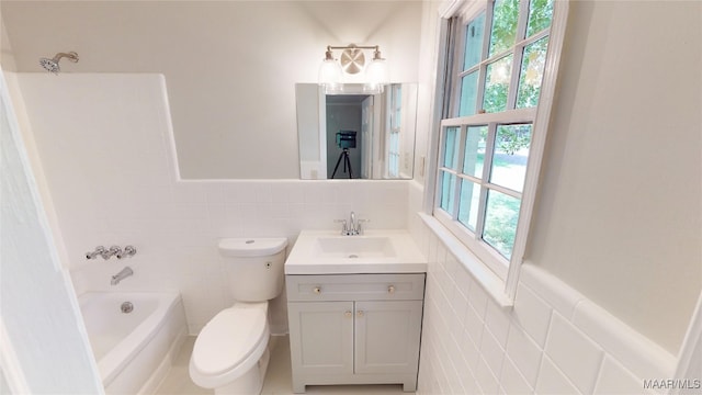 3427 Vance Ln, Montgomery, AL 36109 - bathroom featuring tile walls, vanity, wainscoting, and bathtub / shower combination