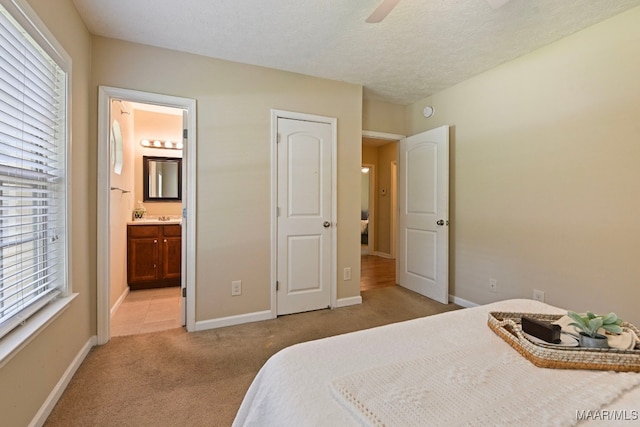 2014 Commodore St, Montgomery, AL 36106 - bedroom featuring light colored carpet, connected bathroom, a textured ceiling, and ceiling fan