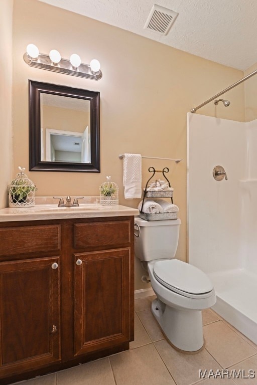 2014 Commodore St, Montgomery, AL 36106 - bathroom with tile patterned flooring, a shower, vanity, and a textured ceiling