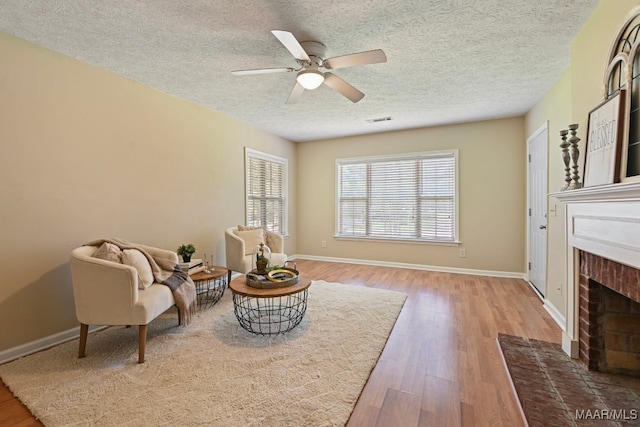 2014 Commodore St, Montgomery, AL 36106 - sitting room with a fireplace, wood finished floors, a textured ceiling, and a ceiling fan