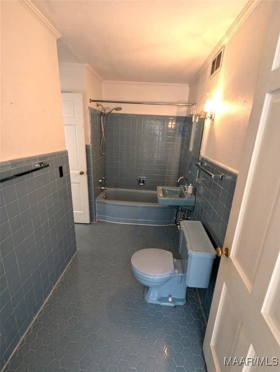 1672 Gilmer Ave, Montgomery, AL 36104 - full bathroom with tile walls, bathtub / shower combination, crown molding, a wainscoted wall, and tile patterned flooring