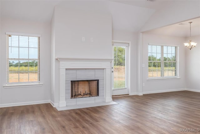 75 Gaines Ct, Wetumpka, AL 36092 - unfurnished living room featuring a chandelier, lofted ceiling, wood finished floors, and a tiled fireplace