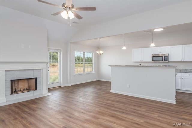 75 Gaines Ct, Wetumpka, AL 36092 - unfurnished living room with vaulted ceiling, a chandelier, a ceiling fan, wood finished floors, and a tiled fireplace
