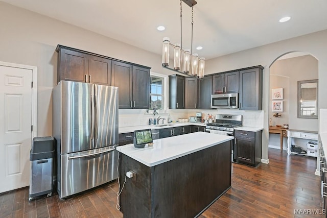 905 Overture Dr, Montgomery, AL 36117 - kitchen with appliances with stainless steel finishes, arched walkways, light countertops, dark brown cabinets, and dark wood-style floors