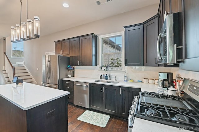 905 Overture Dr, Montgomery, AL 36117 - kitchen featuring stainless steel appliances, decorative backsplash, light countertops, dark wood-style flooring, and a center island