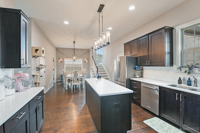 905 Overture Dr, Montgomery, AL 36117 - kitchen featuring appliances with stainless steel finishes, dark wood-type flooring, a center island, tasteful backsplash, and light countertops