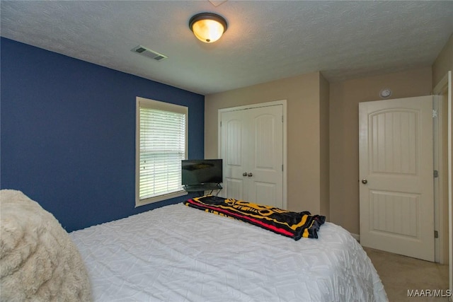 6209 Sycamore Dr, Montgomery, AL 36117 - bedroom with carpet flooring, a textured ceiling, and a closet