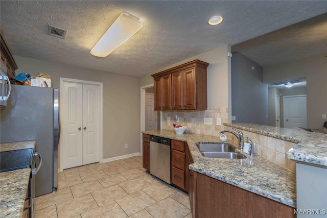 6209 Sycamore Dr, Montgomery, AL 36117 - kitchen with appliances with stainless steel finishes, tasteful backsplash, light tile patterned flooring, a textured ceiling, and light stone counters