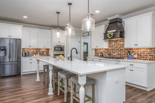 235 Midland Dr, Wetumpka, AL 36093 - kitchen with appliances with stainless steel finishes, custom range hood, tasteful backsplash, a kitchen island with sink, and light countertops