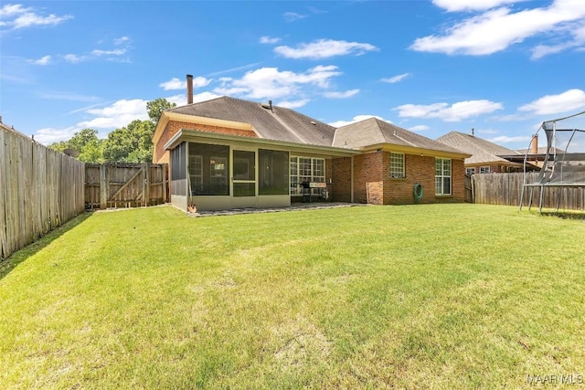 8049 Copperfield Dr, Montgomery, AL 36117 - rear view of property featuring a trampoline, a sunroom, a fenced backyard, a gate, and a shingled roof