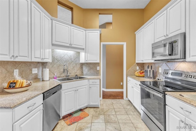 8049 Copperfield Dr, Montgomery, AL 36117 - kitchen featuring appliances with stainless steel finishes, white cabinetry, and decorative backsplash