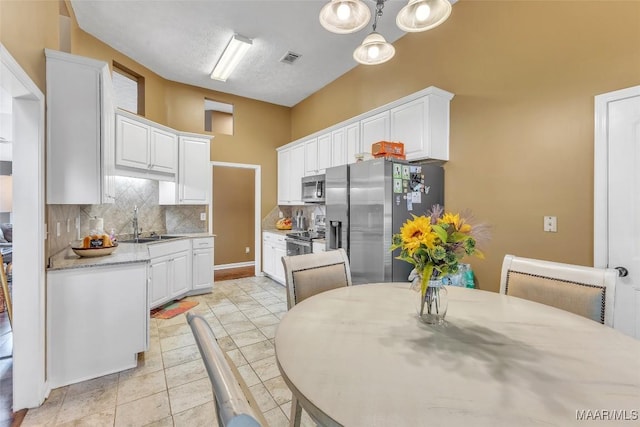 8049 Copperfield Dr, Montgomery, AL 36117 - kitchen featuring stainless steel appliances, backsplash, and white cabinetry