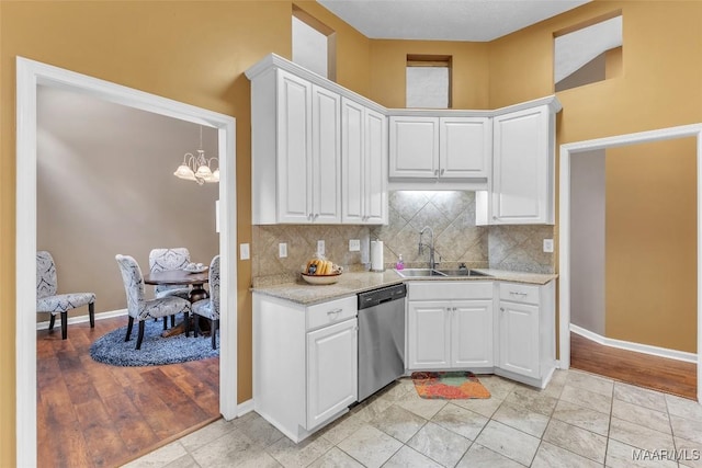 8049 Copperfield Dr, Montgomery, AL 36117 - kitchen with stainless steel dishwasher, a chandelier, white cabinets, and tasteful backsplash