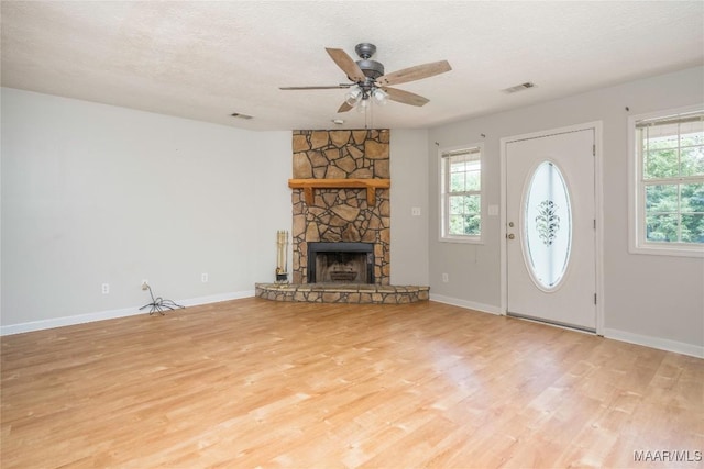 215 Hunters Rd, Eclectic, AL 36024 - unfurnished living room featuring wood finished floors, ceiling fan, a textured ceiling, and a fireplace