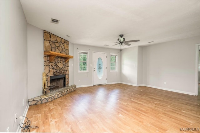 215 Hunters Rd, Eclectic, AL 36024 - unfurnished living room featuring a fireplace, a ceiling fan, and light wood finished floors