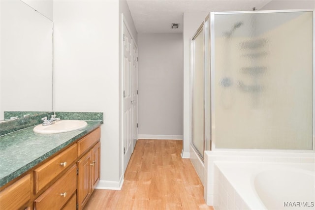 215 Hunters Rd, Eclectic, AL 36024 - bathroom featuring a stall shower, wood finished floors, vanity, and a bath
