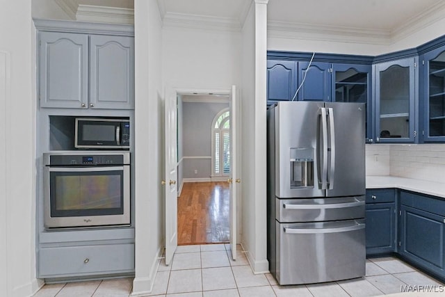7930 Mossy Oak Dr, Montgomery, AL 36117 - kitchen featuring appliances with stainless steel finishes, crown molding, light countertops, glass insert cabinets, and blue cabinetry