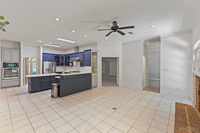 7930 Mossy Oak Dr, Montgomery, AL 36117 - kitchen featuring stainless steel appliances, crown molding, light countertops, ceiling fan, and a fireplace with flush hearth
