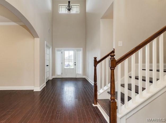 1531 Wingate Park Ct, Montgomery, AL 36117 - entryway featuring arched walkways, a towering ceiling, dark wood-style floors, and stairs