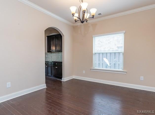 1531 Wingate Park Ct, Montgomery, AL 36117 - empty room featuring ornamental molding, a chandelier, dark wood-style floors, and arched walkways