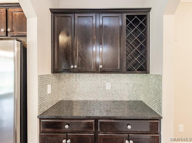 1531 Wingate Park Ct, Montgomery, AL 36117 - kitchen featuring freestanding refrigerator, arched walkways, dark brown cabinets, and tasteful backsplash