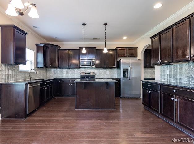 1531 Wingate Park Ct, Montgomery, AL 36117 - kitchen featuring appliances with stainless steel finishes, dark brown cabinets, a center island, crown molding, and recessed lighting