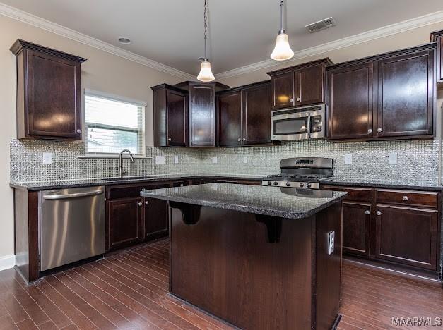 1531 Wingate Park Ct, Montgomery, AL 36117 - kitchen with appliances with stainless steel finishes, a kitchen island, dark brown cabinets, dark wood-style floors, and dark stone countertops