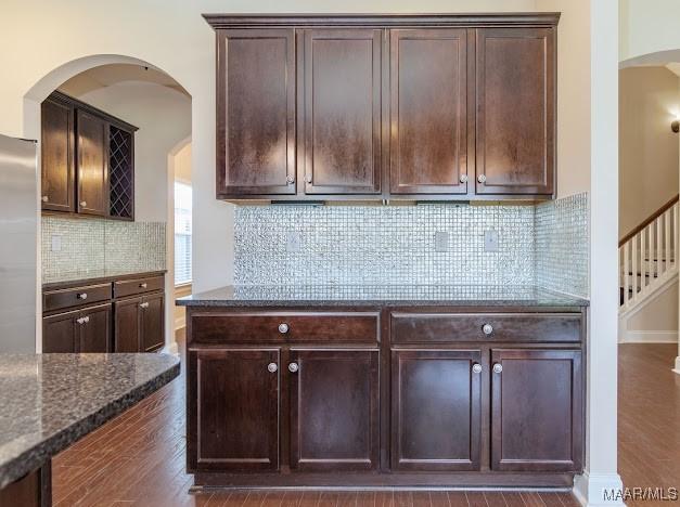 1531 Wingate Park Ct, Montgomery, AL 36117 - kitchen with dark wood finished floors, dark stone countertops, stainless steel built in refrigerator, and dark brown cabinets