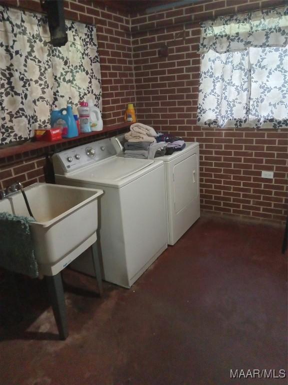 304 Patterson St, Tuskegee, AL 36088 - washroom featuring washing machine and clothes dryer and brick wall