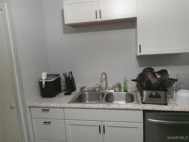 304 Patterson St, Tuskegee, AL 36088 - kitchen with dishwasher, light countertops, and white cabinets